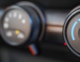 Automotive air conditioning repair service technician inspecting vehicle AC system in Hamilton ON